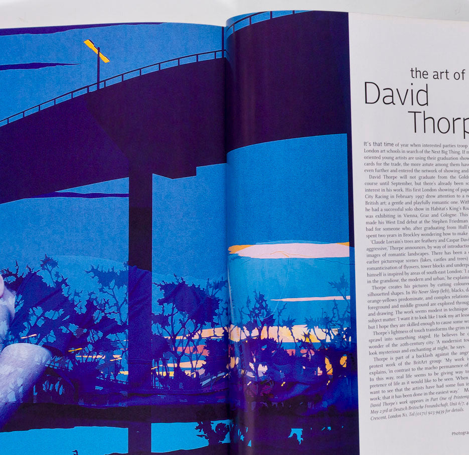 Open book with David Thorpe artwork on a blue bridge and landscape