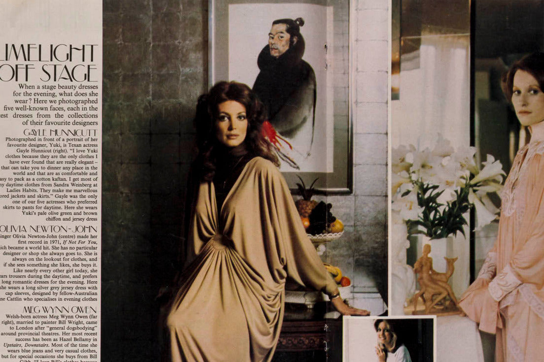 An open vintage magazine spread featuring a fashion article about brown women and sleepwear, with two photos of a woman wearing draped satin robes in beige and pale pink, alongside printed text and interior settings.